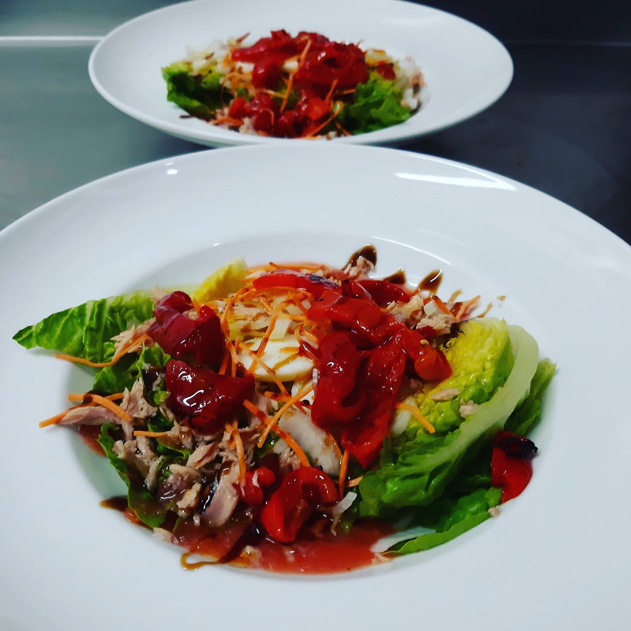 Ensalada mixta con atún, huevo cocido y pimientos asados.